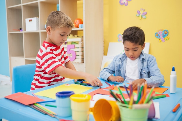 Mignons petits garçons faisant de l&#39;art dans la salle de classe