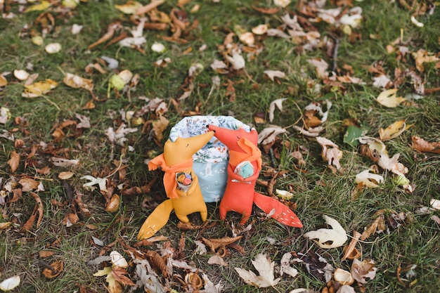 De mignons petits jouets sont assis dans un panier dans le jardin d'automne