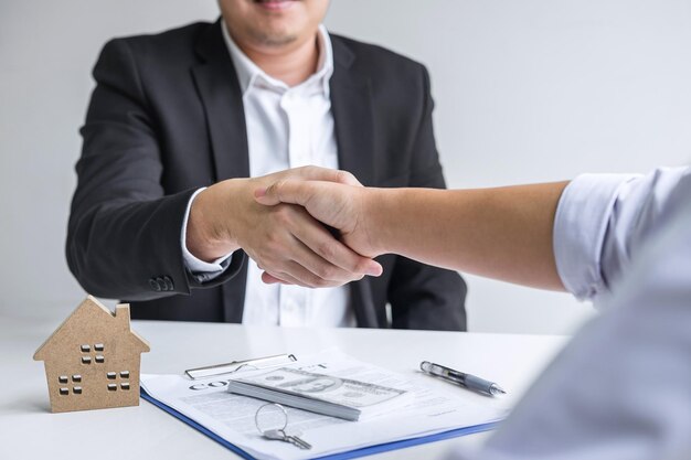 Photo le milieu de l'agent immobilier serrant la main d'un client au bureau