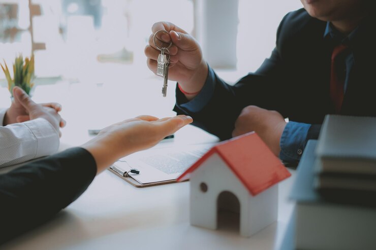 Photo le milieu de l'agent immobilier tenant la clé sur la table