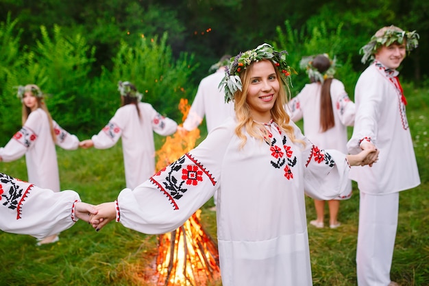 Milieu de l'été. Les jeunes en vêtements slaves tournent autour d'un feu en plein été. .