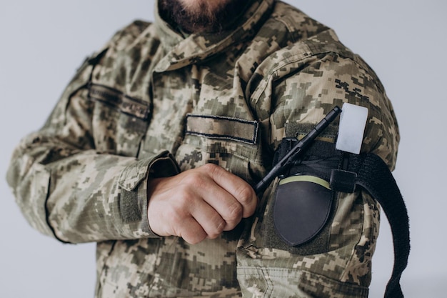 Photo un militaire fait la démonstration d'un garrot médical de combat pour arrêter le sang pendant les premiers soins instructions pour l'équipement tactique de combat