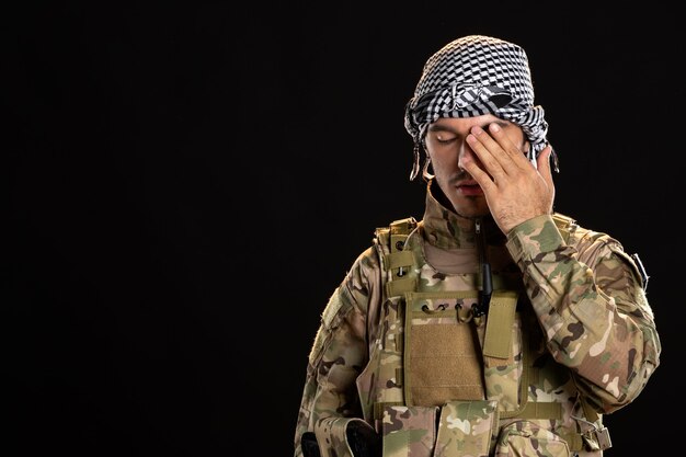 Militaire palestinien en uniforme militaire sur mur sombre