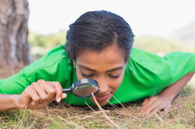 Militant environnementaliste regardant l&#39;herbe à travers la loupe