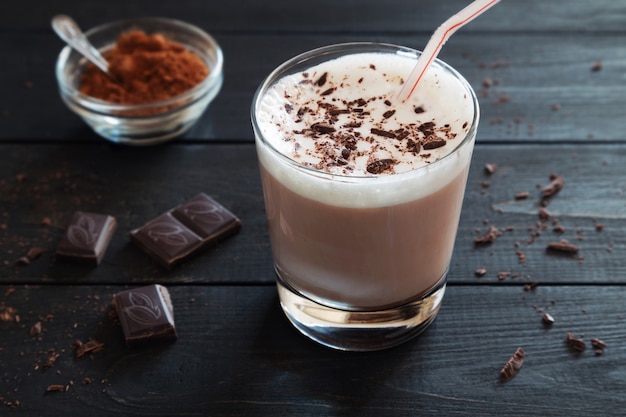 Milk-shake au chocolat et miettes de chocolat sur la table noire