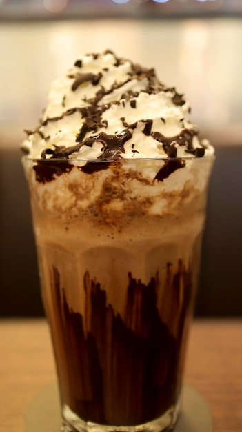 Milk-shake au chocolat plein de crème et de chocolat fondu dans un verre haut à table
