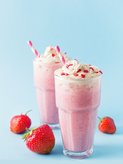 Milk-shake aux fraises ou smoothie et baies crues fraîches sur bleu