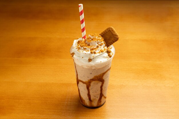 Photo milkshake au caramel avec des biscuits sur un fond de table en bois