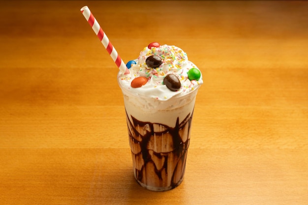 Milkshake au chocolat avec du caramel sur un fond de table en bois