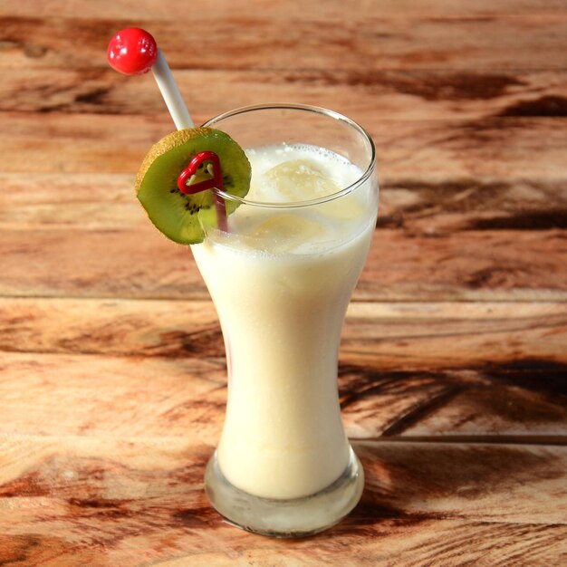 Milkshake aux figues mélangé avec des fruits de figues et de la glace servis dans un verre sur un fond en bois rustique mise au point sélective sur le dessus