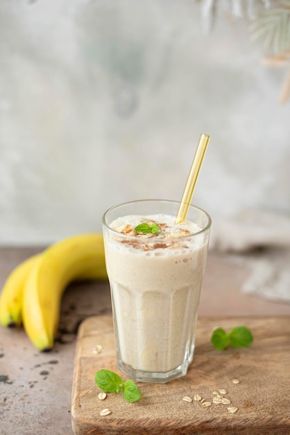 Milkshake à la banane avec flocons d'avoine et cannelle dans un verre