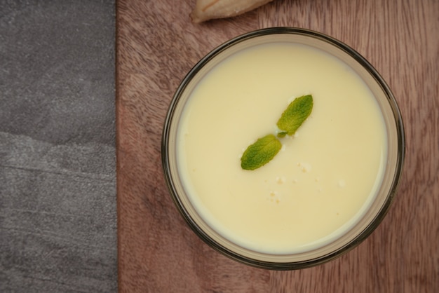 Milkshake banane à la menthe sur planche à découper en bois et torchon en lin