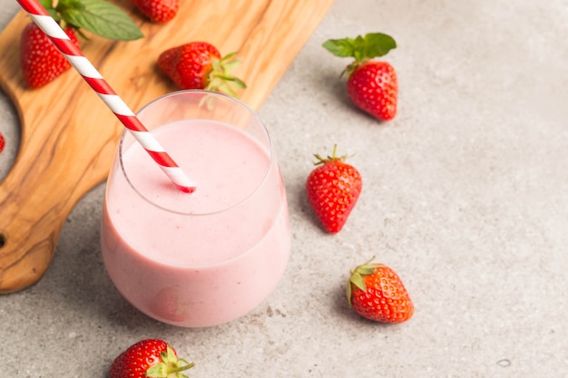 Milkshake frais, smoothie et fraises fraîches sur fond en bois. Concept de boisson saine