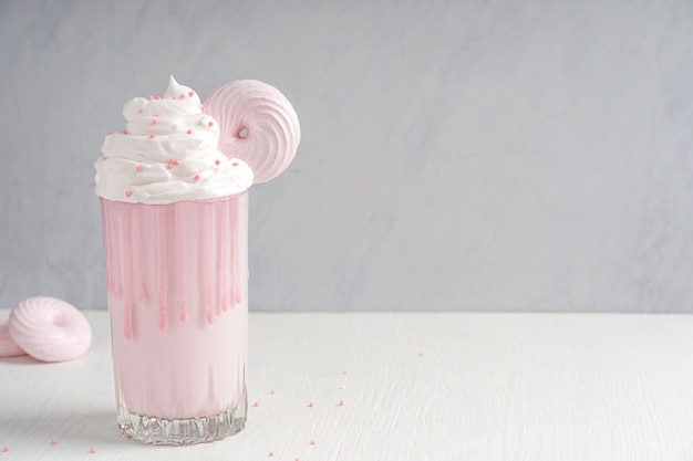 Milkshake rose aux baies une boisson sucrée faite en mélangeant de la crème glacée au lait et des arômes servis dans un verre