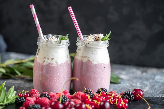 Milkshakes aux fruits rouges dans des bocaux en verre