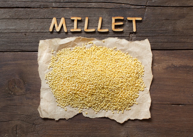 Millet cru avec un mot vue de dessus de millet sur une table en bois