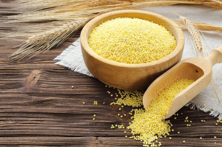 Photo millet dans un bol et épis de blé sur une table en bois marron