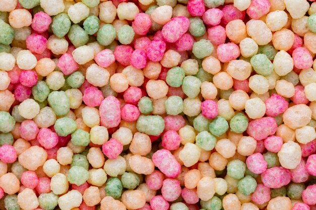Des milliers saupoudrent de minuscules perles de sucre pour décorer des gâteaux et des desserts en arrière-plan.