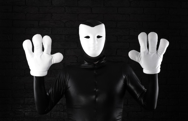 mime drôle dans un masque blanc sur fond noir