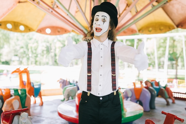 Mime avec un pouce sur un carrousel