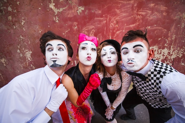 mimes debout sur un mur rouge