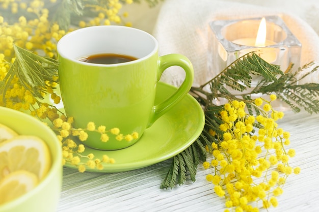 Mimosa, citron et café sur table en bois clair