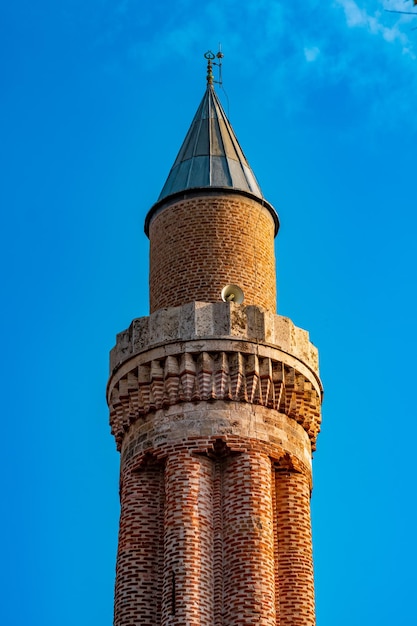 Minaret antique avec des haut-parleurs contre le ciel