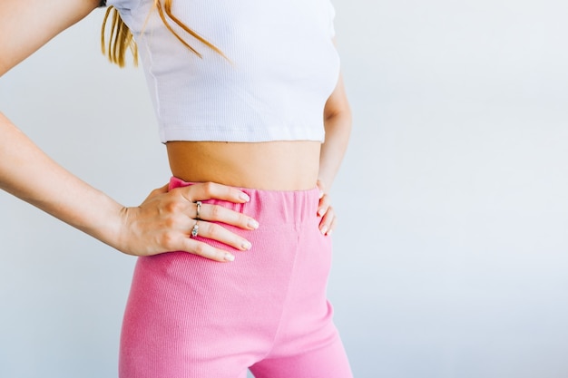 Mince jeune femme avec un corps parfait debout sur fond blanc.