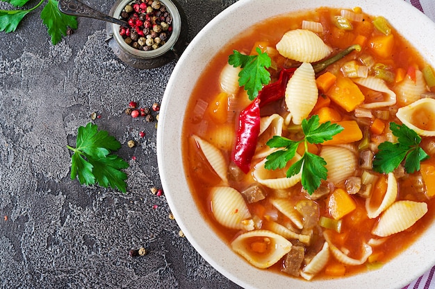 Minestrone, soupe de légumes italiens avec des pâtes sur la table. Nourriture végétalienne. Vue de dessus