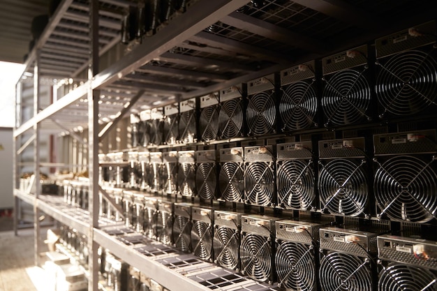 Photo mineurs bitcoin asic dans l'entrepôt équipement minier asic sur des supports pour l'extraction de crypto-monnaie dans un conteneur en acier technologie blockchain stockage d'unités de circuits intégrés spécifiques à l'application