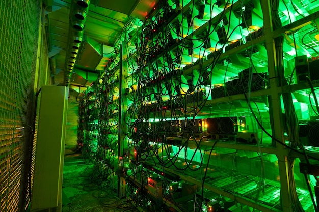 Les mineurs de bitcoins dans de grandes fermes équipement d'extraction ASIC sur des supports de support mine de la crypto-monnaie dans un conteneur en acier application de technologie blockchain circuit intégré spécifique centre de données lumières de salle de serveur