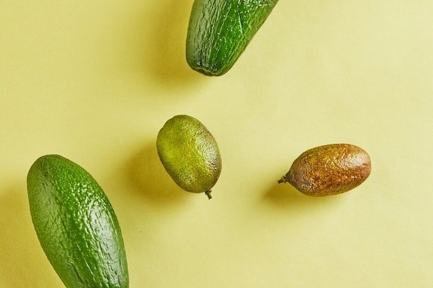 Mini avocats frais mûrs et mini citrons isolés