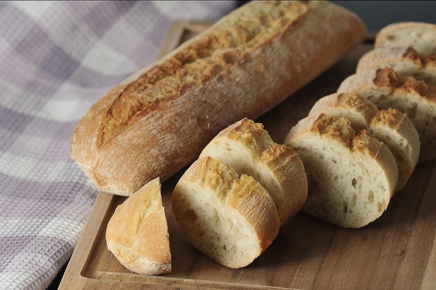 Mini baguette entière et coupée en morceaux sur fond de bois - cuisine française