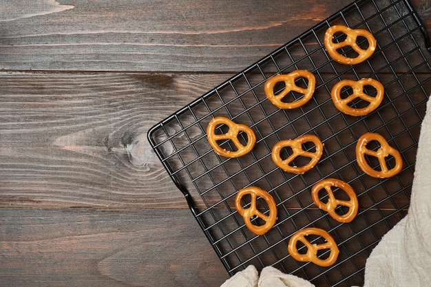 mini bretzels salés sur fond en bois de grille de refroidissement en fil. craquelins durs ou collations. vue de dessus,