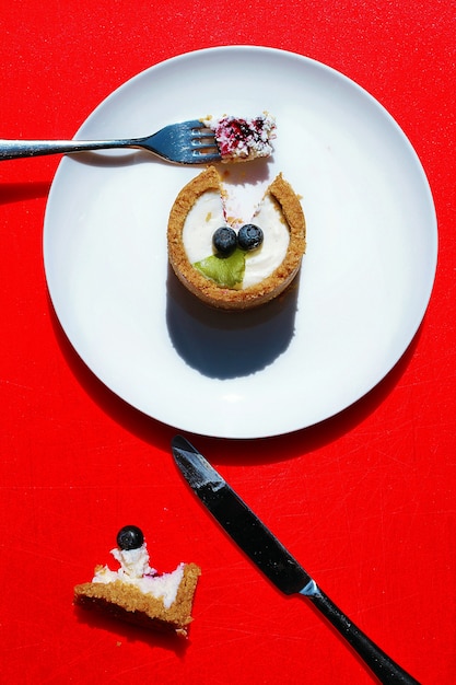 Mini cheesecake décoré de myrtilles sur fond rouge