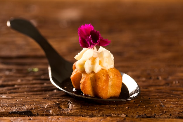 Mini churros salés, accompagnés d'une réduction de café aromatisé au Kombu et farcis de fromage à la crème à l'orange confite dans une cuillère. Goûtez la fingerfood de la gastronomie