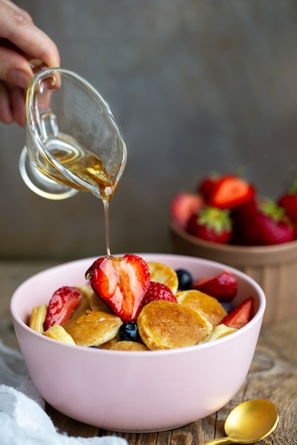 Mini crêpes dans un bol avec du sirop d'érable