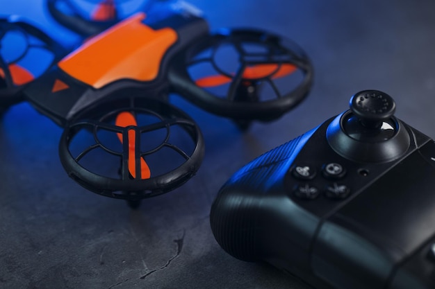 Photo mini drone orange de jeu sur fond sombre avec une manette de commande