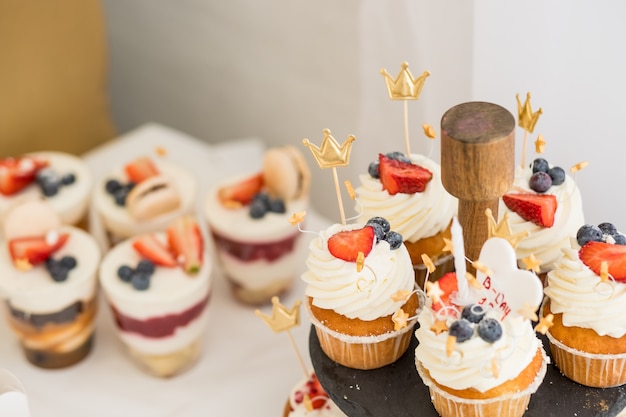 mini gâteaux. Bonbons pour les vacances.Gâteau savoureux.Petits gâteaux avec diverses baies et crème à la vanille.Le macaron est une confiserie à base de meringue sucrée.