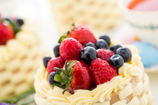 Mini-gâteaux de panier de Pâques avec des fruits frais glacés sur le dessus.