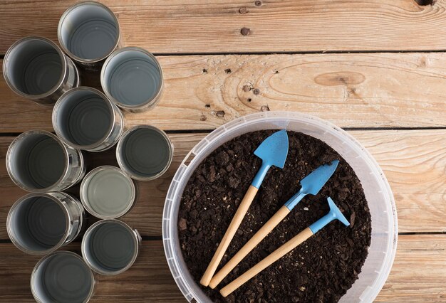 mini jardin avec des canettes en aluminium recyclées sur une table en bois rustique