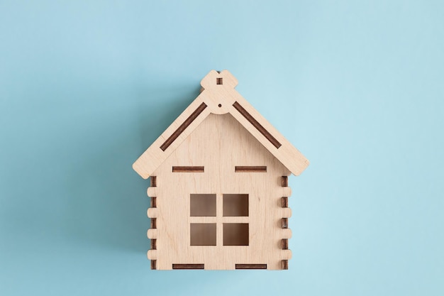 Mini maison en bois sur fond bleu Concept de prêt de résidence et de maison