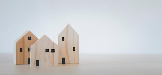 Mini modèle de maison en bois à partir du modèle sur table en bois, Planification d'achat immobilier, Planification d'achat d'une propriété et Choisissez le meilleur. travailler à domicile et rester à la maison concept.