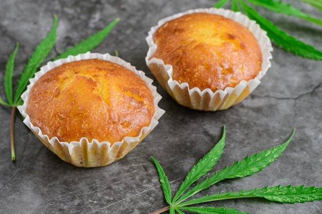 Mini muffins à la cannelle fraîchement cuits au four avec du cannabis et des bourgeons de marijuana sur la table