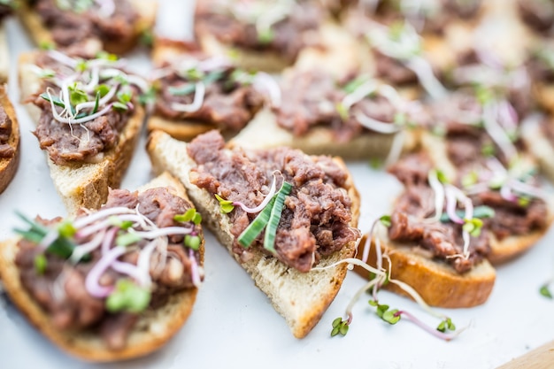 Photo mini pains de tartare de boeuf cru sur une table de restauration à l'événement.