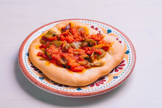 Mini pizza fraîchement sortie du four avec tomates et légumes. Pâtisserie traditionnelle espagnole aux légumes.