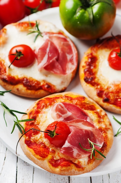 Mini pizza à la mozzarella, au prosciutto et à la tomate