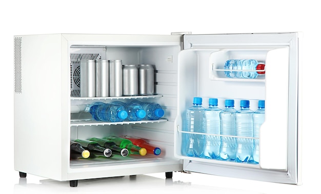 Photo mini-réfrigérateur plein de bouteilles et bocaux avec diverses boissons isolées sur blanc