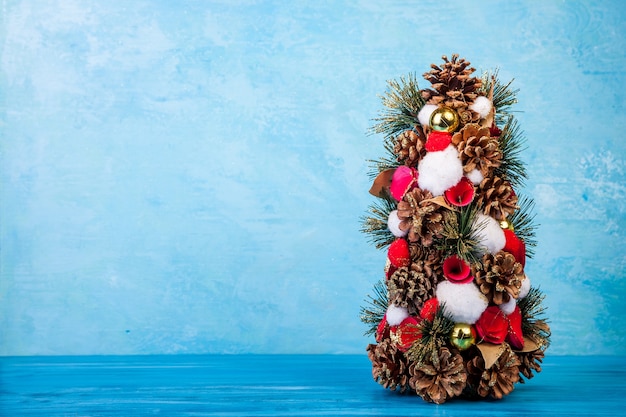 Mini sapin de Noël sur fond bleu en photo studio. Saisonnier et vacances