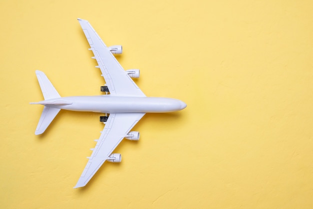 Miniature d'un avion sur fond jaune avec un espace de copie, vue du dessus